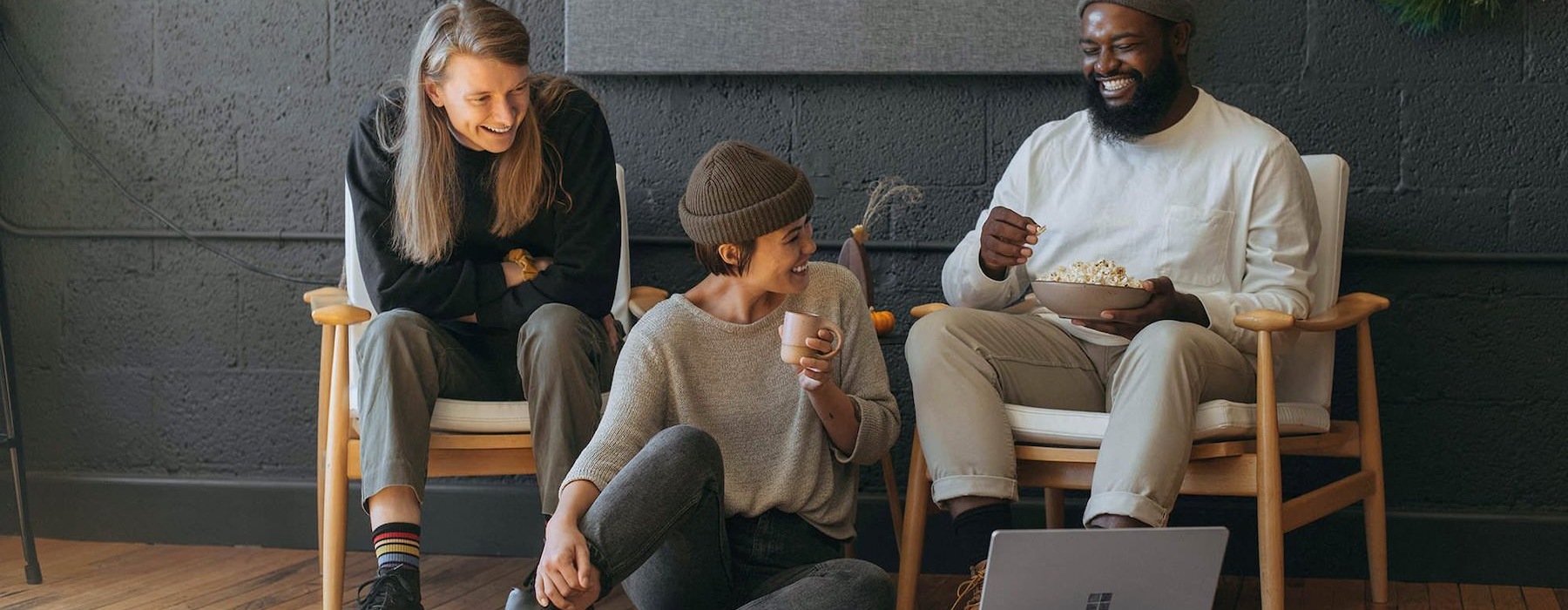 friends sit together around an open laptop